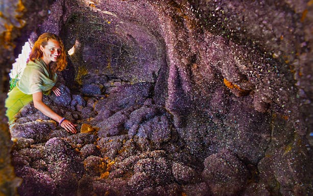 Woman exploring amethyst cave at Crystal Castle & Shambhala Gardens, Byron Bay.