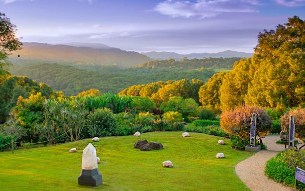 Crystal Castle gardens with lush greenery and distant mountain views in Byron Bay.