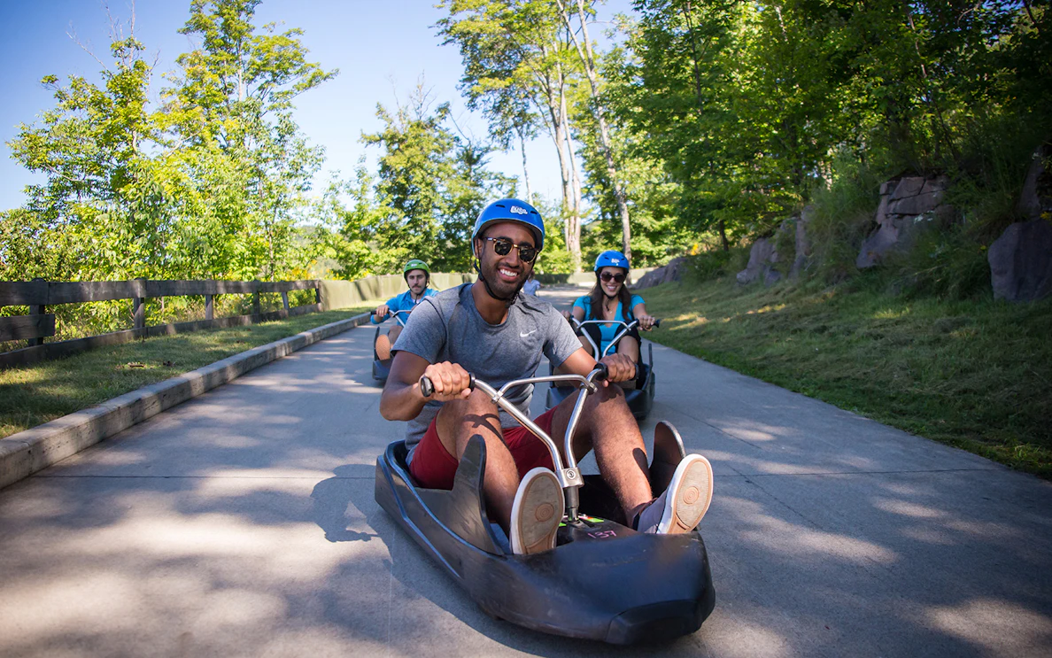 People riding luge carts on a track at Skyline Luge Sentosa.