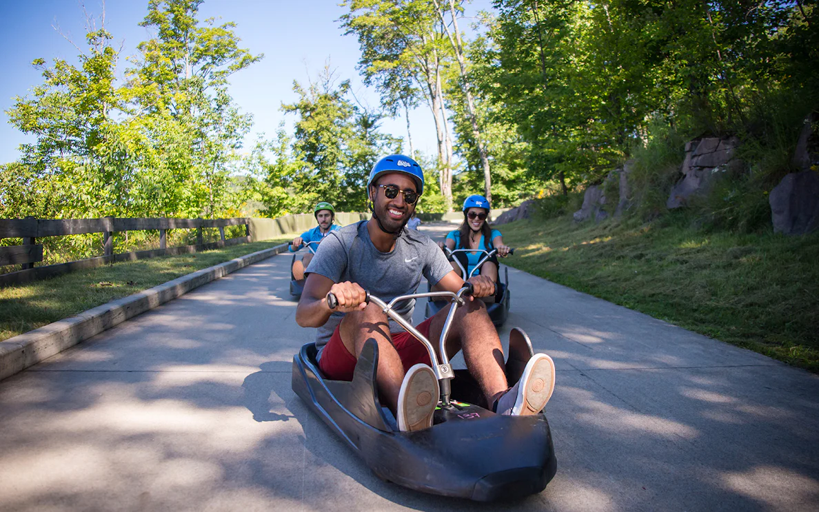 People riding luge carts on a track at Skyline Luge Sentosa.