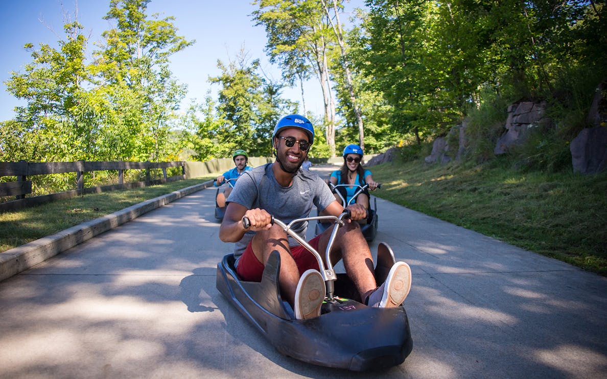 People riding luge carts on a track at Skyline Luge Sentosa.