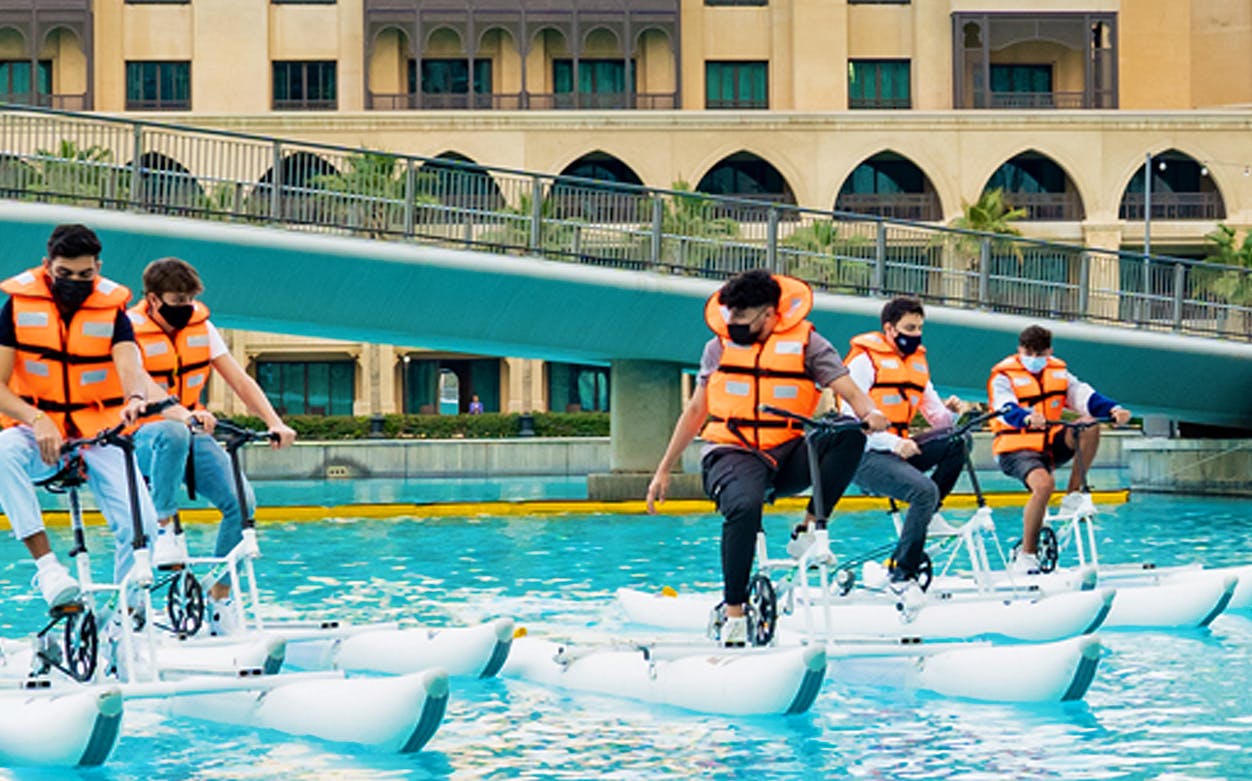 People riding water bikes at Dubai Fountain.