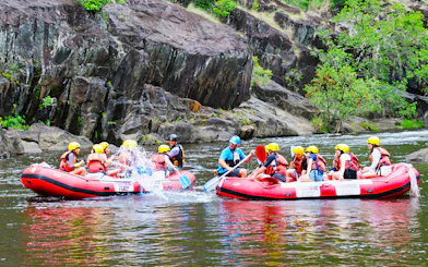 Rafters navigating Barron River rapids in Cairns, Australia, during half-day tour.