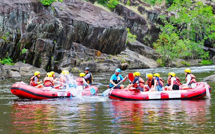 Rafters navigating Barron River rapids in Cairns, Australia, during half-day tour.
