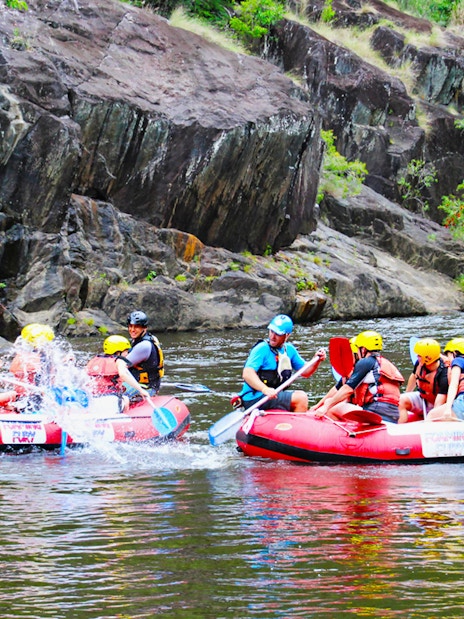 Rafters navigating Barron River rapids in Cairns, Australia, during half-day tour.