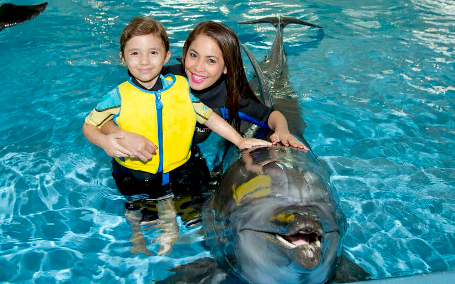 Woman and child with dolphin at Dubai Dolphinarium.