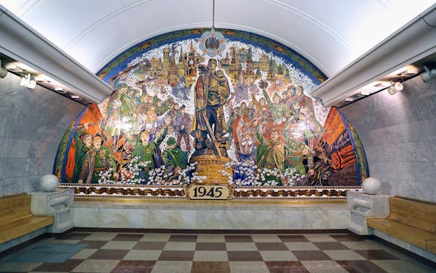 Mural in Moscow Metro station depicting 1945 victory celebration, part of guided tour.