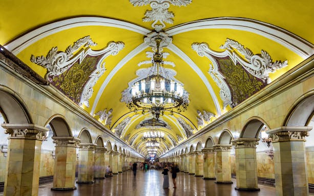 Komsomolskaya Metro Station in Moscow with ornate chandeliers and decorative arches.