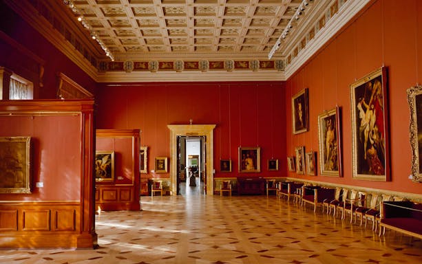 Hermitage Museum gallery with classic paintings and ornate ceiling in Saint Petersburg.