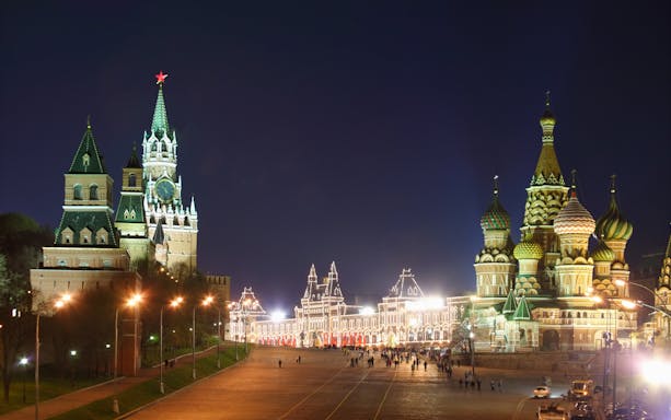 Kremlin and St. Basil's Cathedral illuminated at night during Moscow city walking tour.