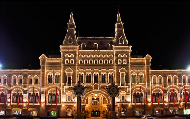 Illuminated GUM department store at night during Moscow city tour.