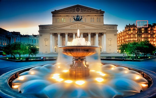 Bolshoi Theatre and illuminated fountain at dusk, Moscow.