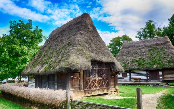 Traditional thatched-roof houses at Village Museum, Bucharest.