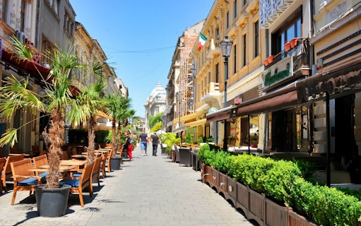 Bucharest street with cafes and historic buildings on a sightseeing tour.