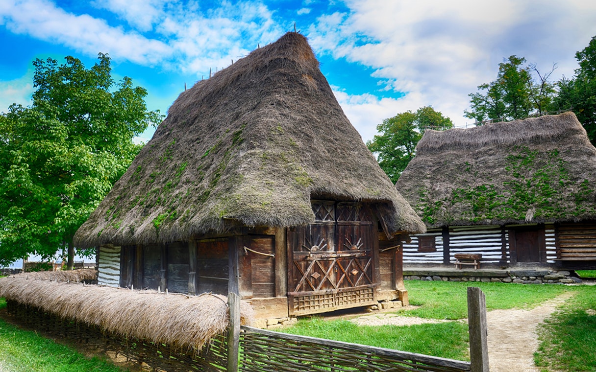 Traditional thatched-roof houses at the Village Museum in Bucharest.