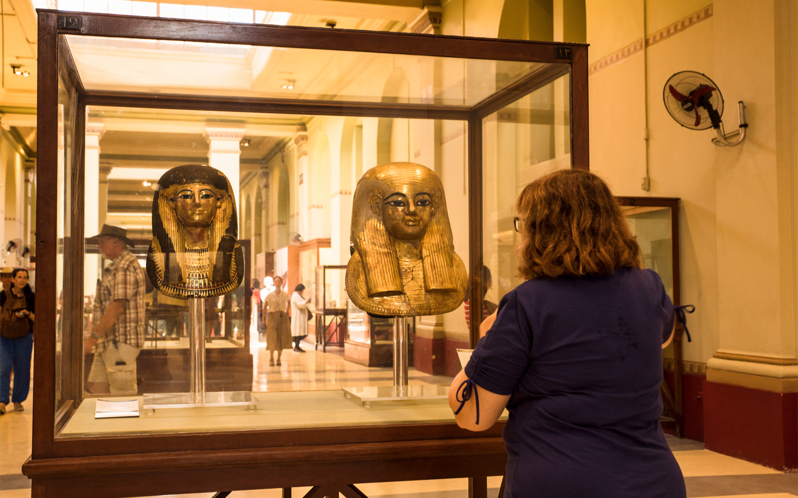 Visitor viewing ancient Egyptian masks at the Egyptian Museum in Cairo.