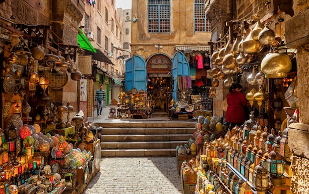 Bustling Cairo bazaar with colorful lanterns and traditional goods, part of the Egyptian Museum tour.
