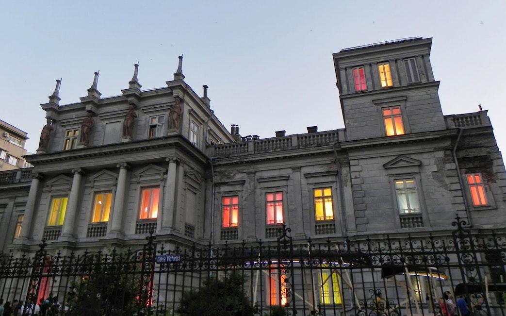 Historic building with colorful lit windows on Calea Victoriei, Bucharest, part of the Underground City tour.