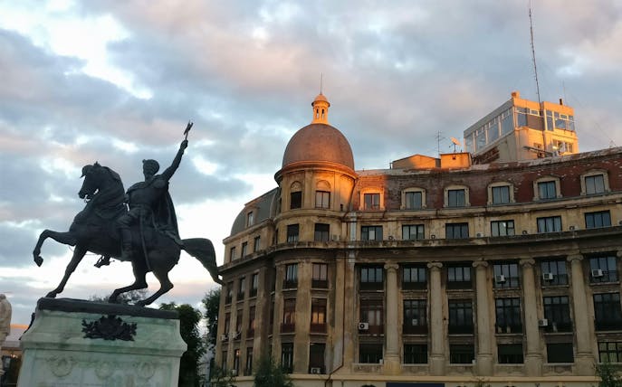 Equestrian statue in front of historic building during Underground Bucharest City tour.