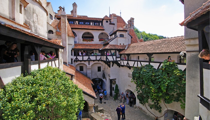Bran Castle courtyard with tourists exploring Dracula's historical site in Romania.