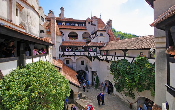 Bran Castle courtyard with tourists exploring Dracula's historical site in Romania.