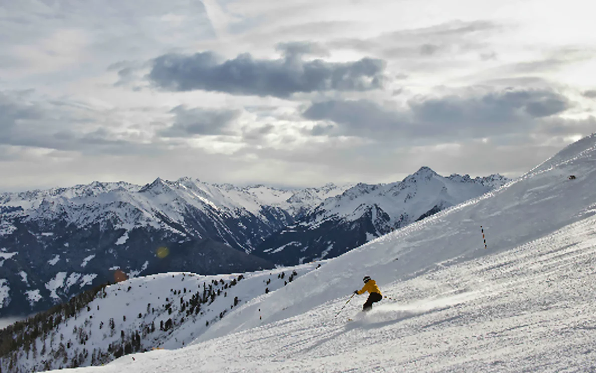 Skier on snowy slope with mountain view, Mayrhofen Zillertaler Superskipass.