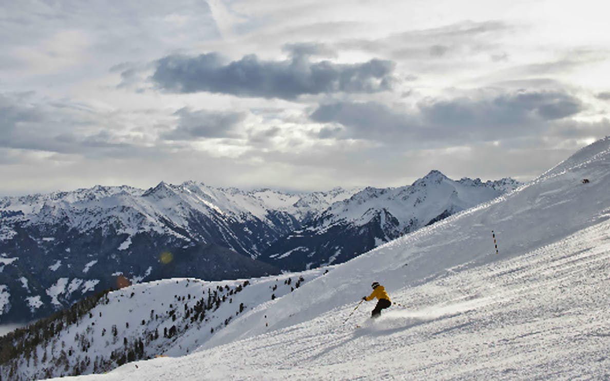 Skier on snowy slope with mountain view, Mayrhofen Zillertaler Superskipass.