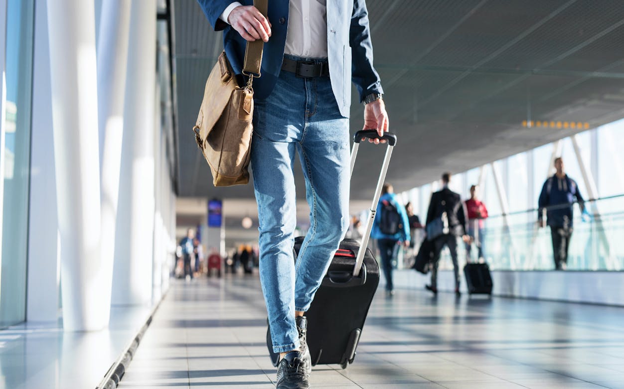 Traveler with luggage walking through Cairo airport terminal.