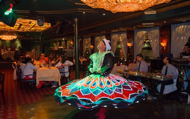 Dancer performing on the Nile Maxim dinner cruise with live music and dining guests.