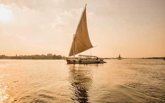 Felucca sailing on the River Nile during sunset in Egypt.