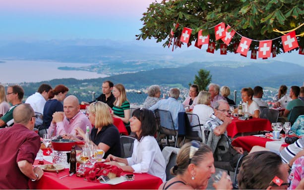 Dining with a view of Lake Zürich during an evening tour, featuring gourmet dinner and cheese fondue.