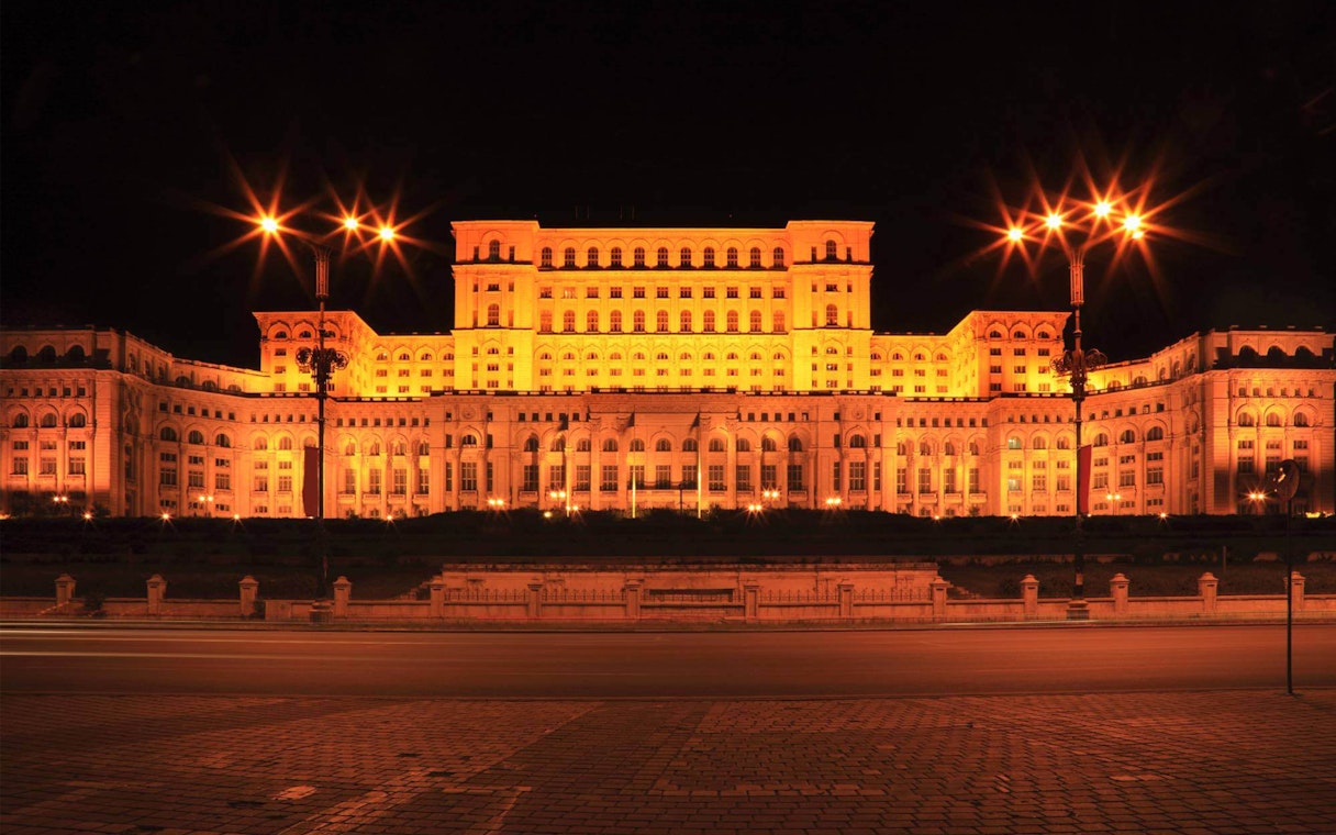 Palace of the Parliament illuminated at night during After Dark City Tour in Bucharest.