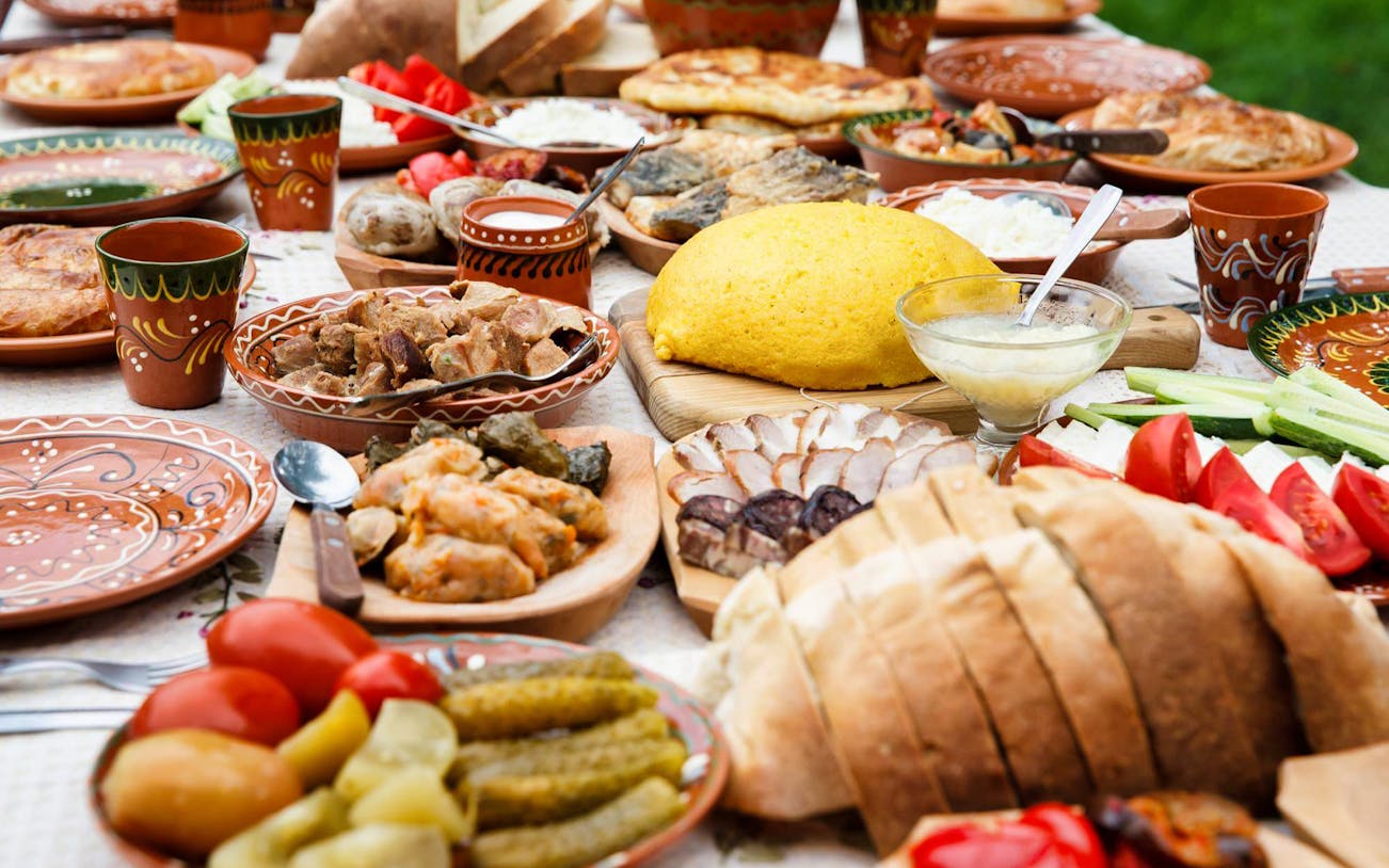 Traditional dinner spread with various dishes and bread, part of the After Dark City Tour.