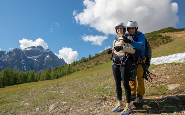 Tandem paragliding preparation in Tirol with scenic mountain backdrop.