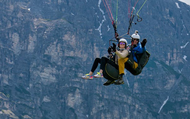 Tandem paragliding over mountainous landscape in Tirol.