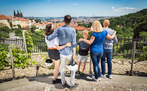 Tourists overlooking Prague cityscape on E-Scooter Grand City Tour.