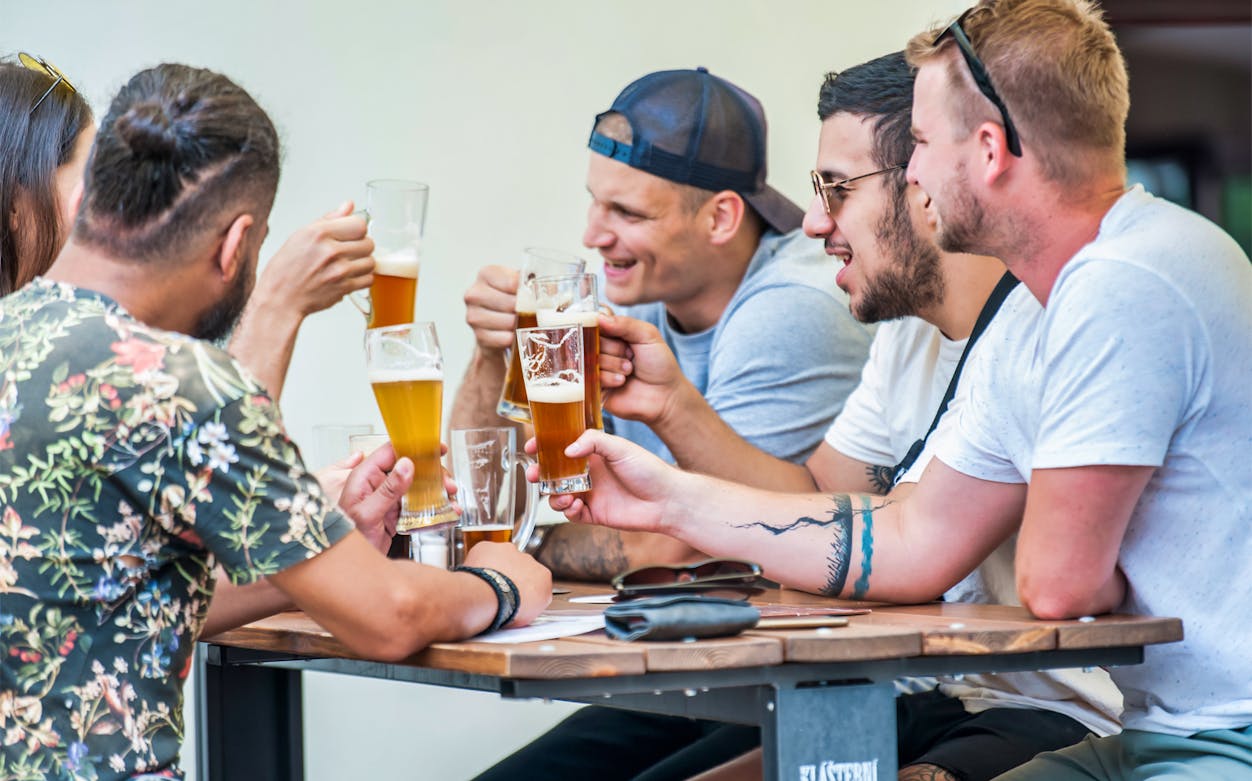 Group enjoying beer at an outdoor table in Prague's Old Town.