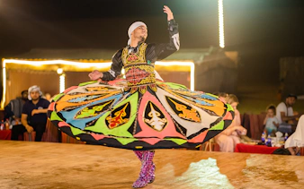 Dancer performing traditional Tanoura dance in Dubai desert camp.