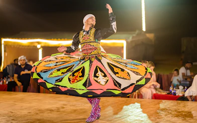 Dancer performing traditional Tanoura dance in Dubai desert camp.