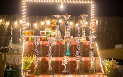 Hookah display at a desert safari in Dubai, featuring various flavors and a vendor.