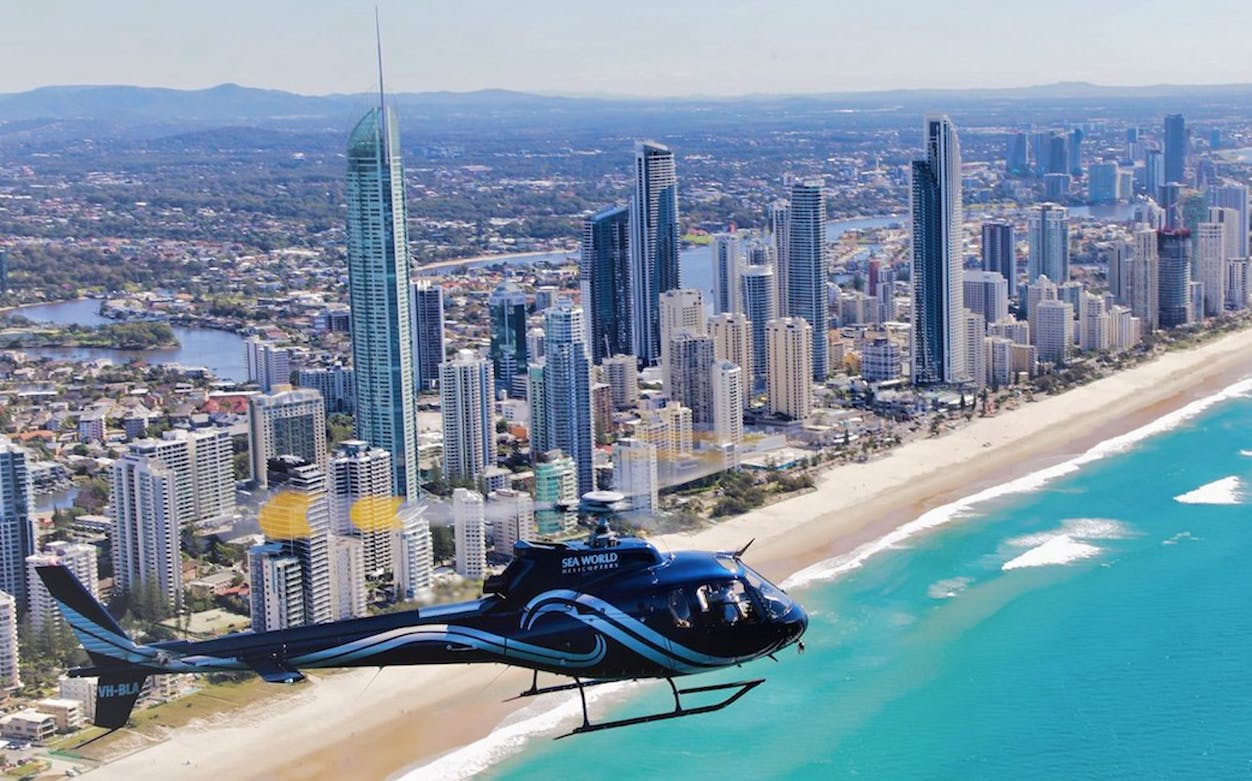 Helicopter flying over Gold Coast skyline and beach during Sea World Scenic Flight.