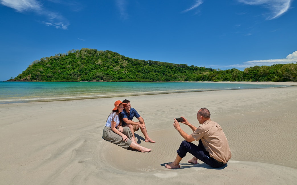 Couple posing for a photo on Cape Tribulation beach during guided tour, Daintree.