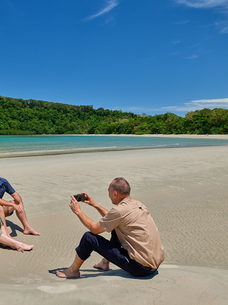 Couple posing for a photo on Cape Tribulation beach during guided tour, Daintree.