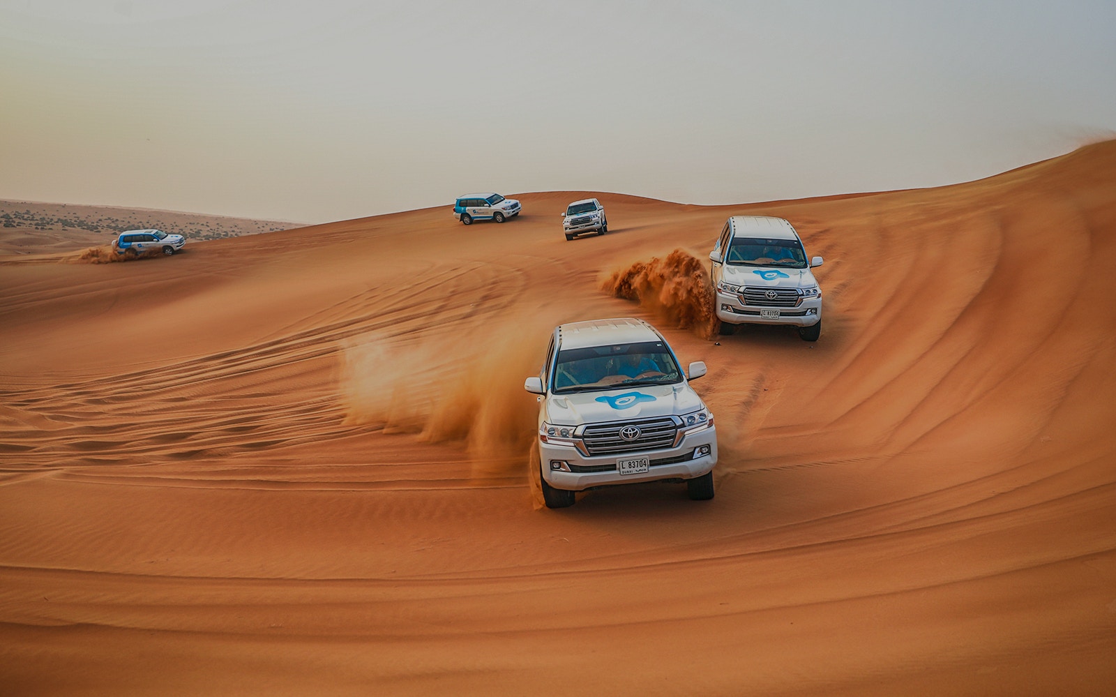 4x4 vehicles dune bashing in Dubai desert during morning safari.