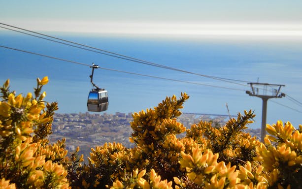 Cable car over Benalmadena with city and sea view in the background.