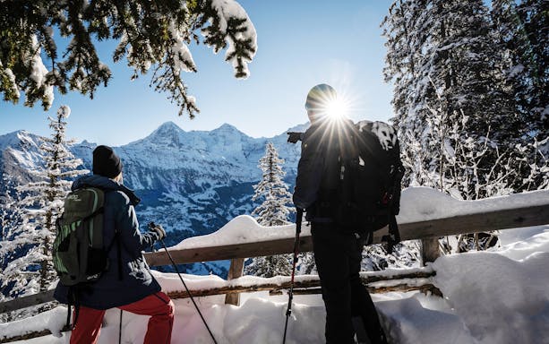 Snowshoers overlooking snowy mountains on Isenfluh tour from Interlaken.