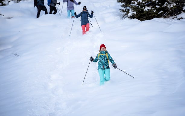 Snowshoers descending a snowy trail near Isenfluh on a guided tour from Interlaken.