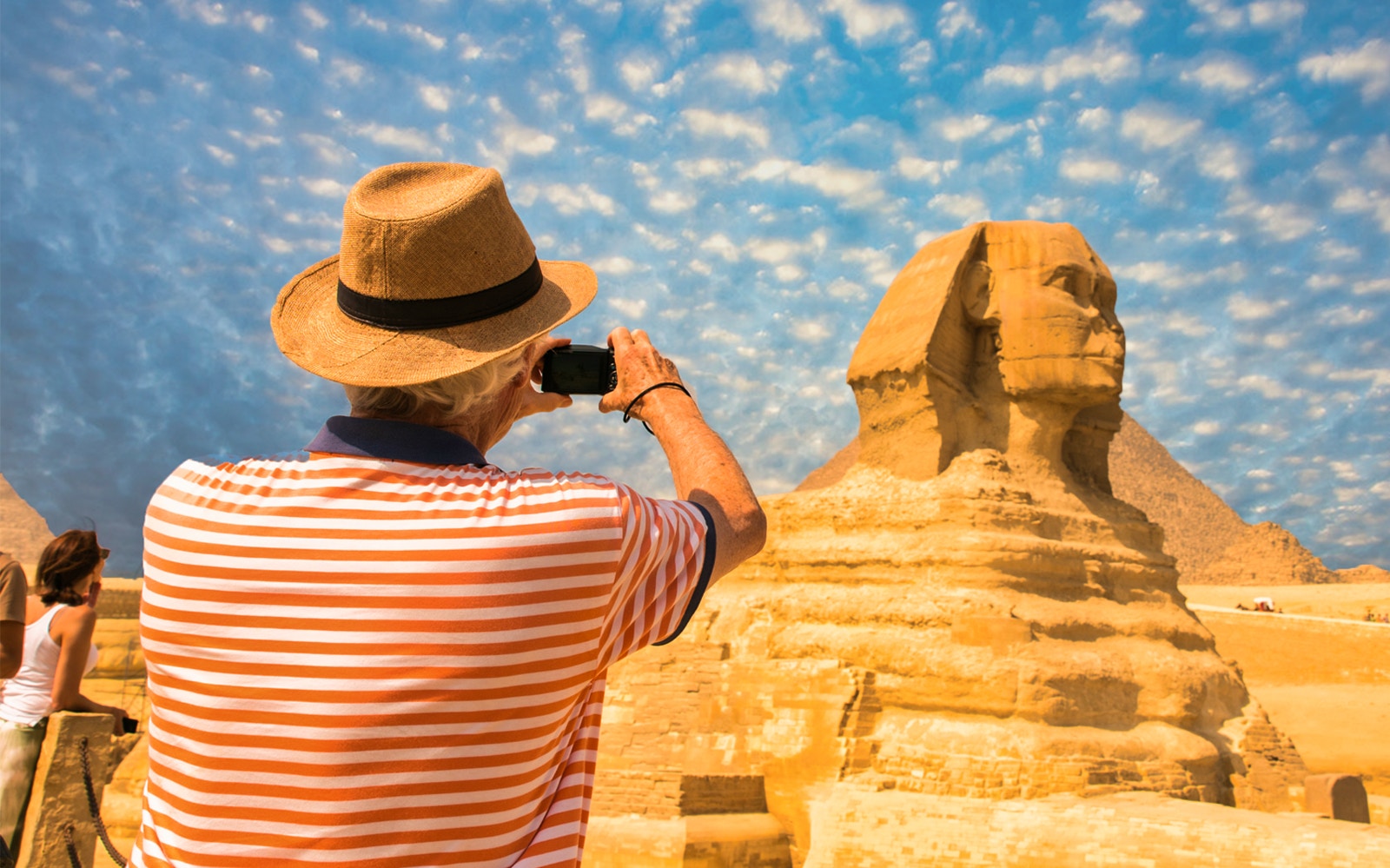 Tourist photographing the Sphinx during Giza Pyramids tour from Cairo.