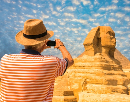 Tourist photographing the Sphinx during Giza Pyramids tour from Cairo.