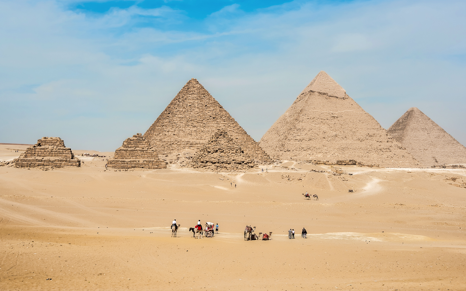 Giza Pyramids with tourists on camels, part of the Giza, Saqqara, Dahshur tour from Cairo.